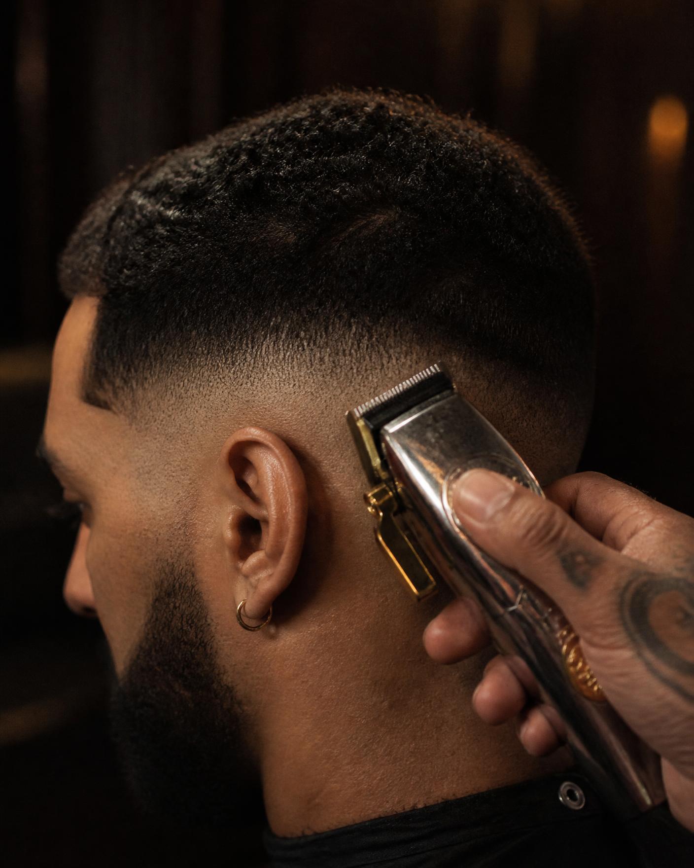 Barber finishing a crisp skin fade with clippers